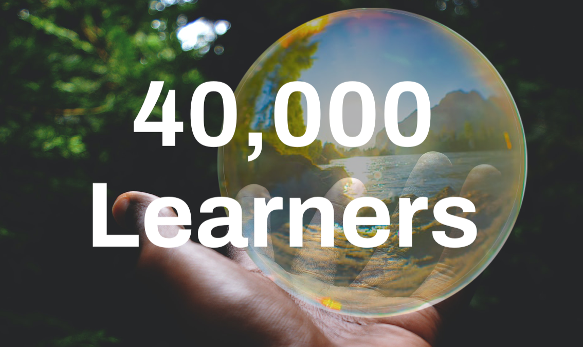 40,000 Learners text over image of hand holding globe logo